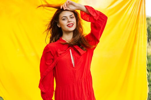 pretty woman in red dress outdoors nature yellow cloth. High quality photo