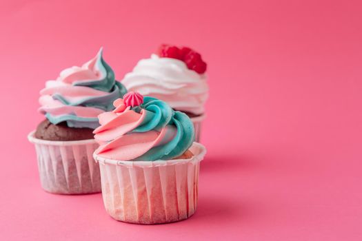 Tasty cupcakes sweets on pink background close up