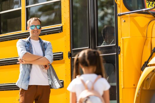 school bus driver is standing in front of his bus