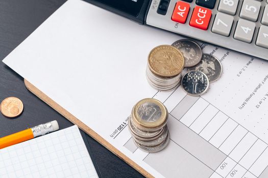 pile of money coins with graph paper on wood table, concept in account, finance and growth of business