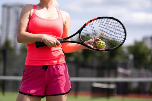 Woman playing tennis holding a racket and smiling