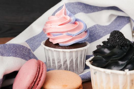Delicious raspberry and caramel cupcakes on dark background