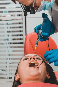 The dentist with the help of a carpule syringe injects anesthesia into the patient's gums, local anesthesia.2020