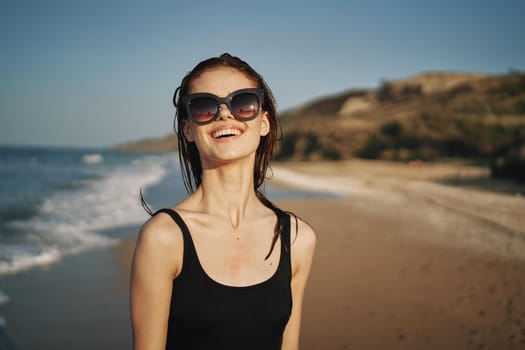 woman walks along the sandy shore in a black swimsuit sun tropics. High quality photo