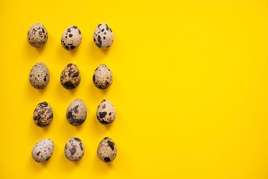 Quail Easter eggs on yellow background. Easter elements. Easter background. Easter pattern. Top view. Flat lay. Minimal concept.