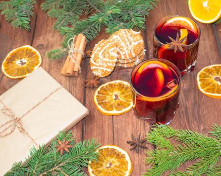 Mulled wine and spices on a wooden background with branches of a Christmas tree. Selective focus.