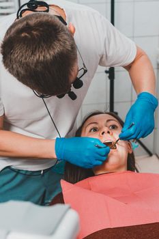 The dentist examines the oral cavity before treating the problem areas of the teeth.2020