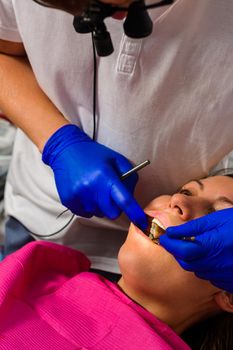 The dentist examines the oral cavity before treating the problem areas of the teeth.2020