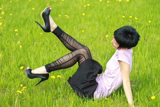 funny woman is lying on the grass