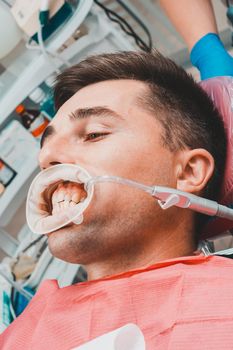 The procedure at the dentist,the dentist prepares the patient and tools to remove tartar, saliva ejector and retractor in the patient's mouth.2020