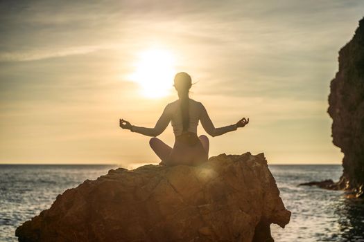 Young woman practicing yoga outdoors. Harmony and meditation concept. Healthy lifestyle.