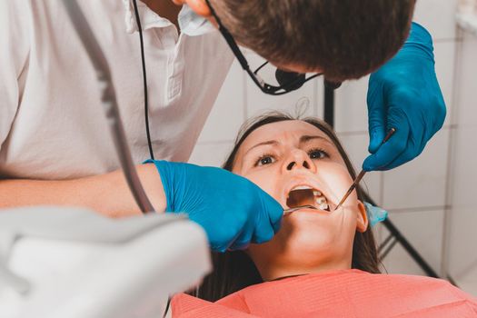 The dentist examines the oral cavity before treating the problem areas of the teeth.2020