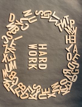Word Hard Work In Wooden Cube Alphabet Letters Top View On A rustic paper Background.