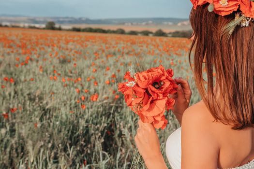 Bride in a white dress holding a bouquet of poppy flowers, warm sunset time on the background of the lavender field. Copy space. The concept of calmness, silence and unity with nature.