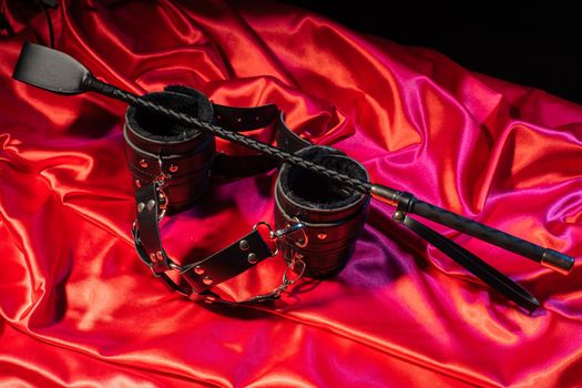 Adult sex games. Kinky lifestyle. Spank and Bondage on the red linen. Bdsm outfit - Image