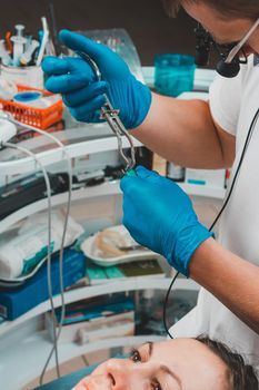 Installation of a rubber dam with a metal clamp for dental fillings, sterile and modern dental treatment.2020