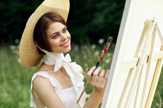 Woman in white dress artist paints on nature palette creative. High quality photo