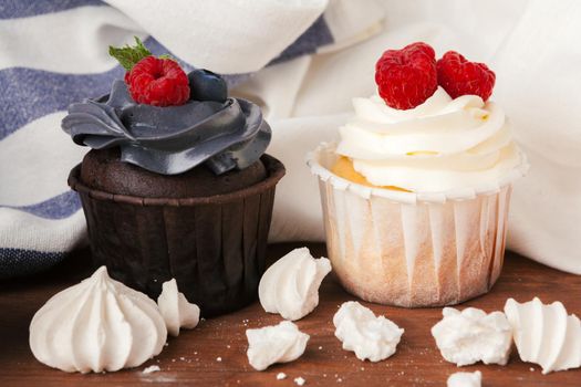 Delicious raspberry and caramel cupcakes on dark background