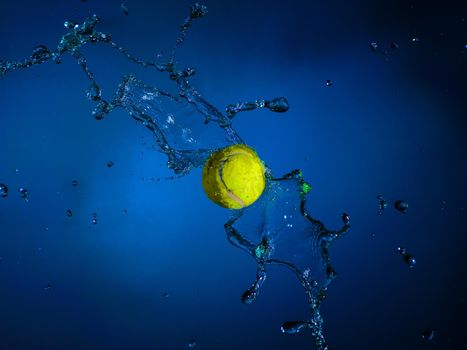 Sports ball and splashes of water on a blue background.