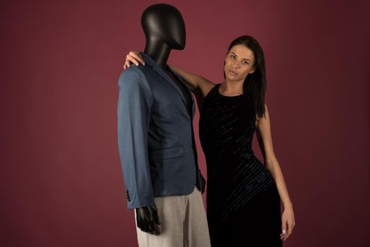 A young girl with problematic skin suffers from loneliness in a society of stylish manikins on ruby background.
