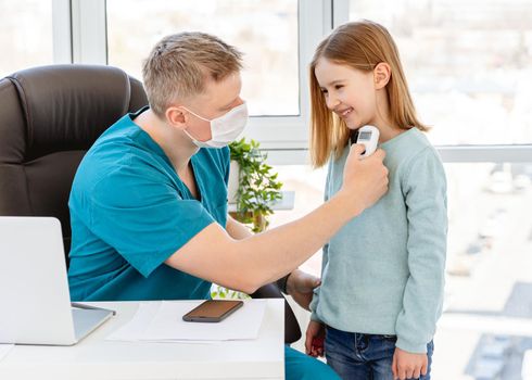 Cute little girl measuring temperature at doctor