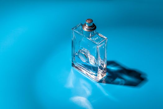 perfume glass bottle on light blue background. Eau de toilette