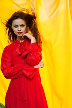 pretty woman in red dress nature yellow cloth on background. High quality photo