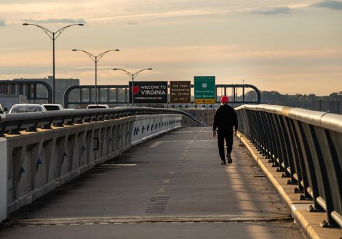Alexandria, VA - 4 November 2021: Man walking over the Woodrow Wilson bridge trail towards Virginia