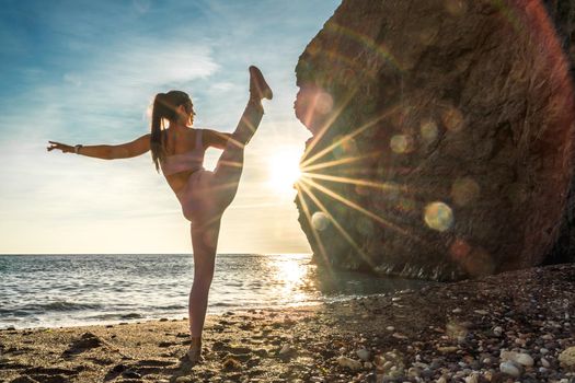 Girl gymnast is training on the beach by the sea sunset. Does twine. Photo series