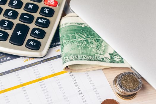 Close up of a calculator and coins on a business background