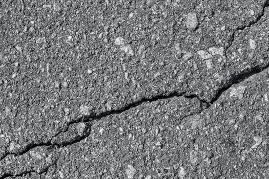 Asphalt with crack background. Old gray road for background or texture. Asphalt as abstract background or backdrop. Banner toned in trendy color of 2021 Ultimate Grey