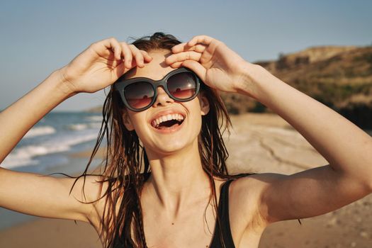 cheerful woman sunglasses posing black swimsuit island. High quality photo