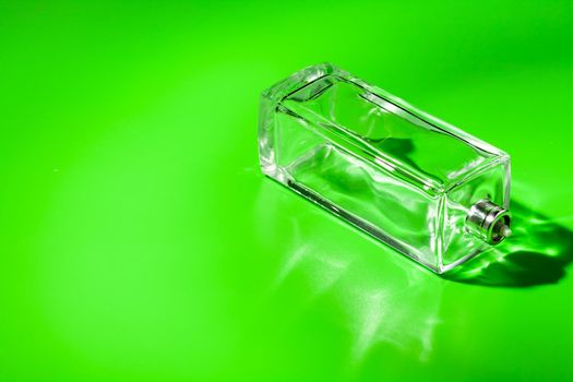 perfume glass bottle on light green background. Eau de toilette