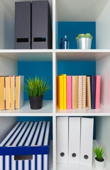 White office shelves with different stationery, close up