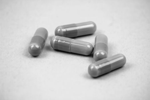 Group of pills on surface. Monochrome picture