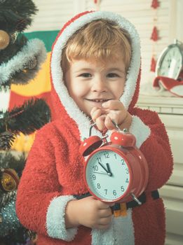 Santa kid boy. Christmas happy child with gift clock.