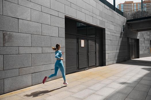 Beautiful fit young woman jogger is running outdoors