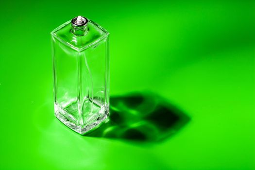 perfume glass bottle on light green background. Eau de toilette