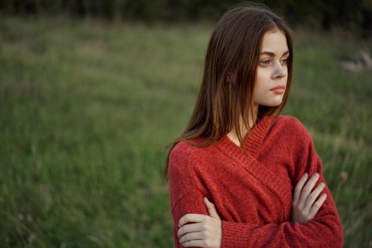 woman in a red sweater outdoors in a field walk. High quality photo