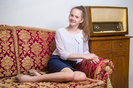 Beautiful little girl on an old radio. The concept of old things, Nostalgia, Vintage.