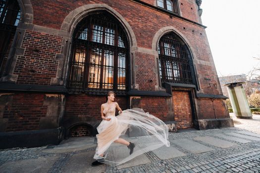 A bride in a wedding dress with long hair in the old town of Wroclaw. Wedding photo shoot in the center of an ancient city in Poland.Wroclaw, Poland.