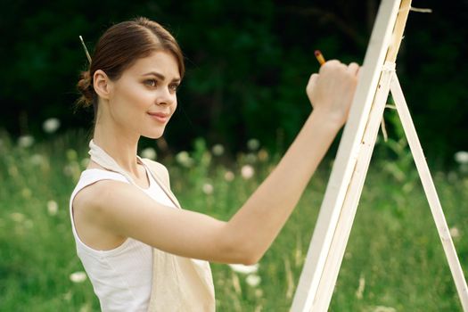 woman artist paints a picture on nature art hobby. High quality photo