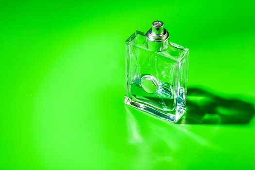 perfume glass bottle on light green background. Eau de toilette