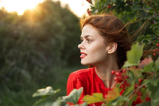 pretty woman in red shirt nature green leaves summer. High quality photo