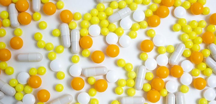 different colorful pills, capsules. Prevention, cure of influenza, coronavirus, covid-19, 2019-nCoV. yellow, orange vitamins, tablets on white background. medical healthcare, protection concept banner