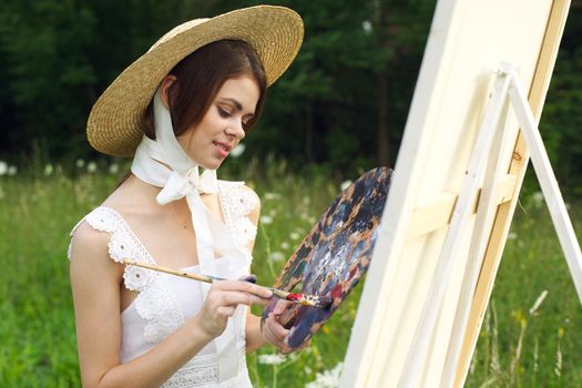 Woman in white dress outdoors artist drawing easel. High quality photo