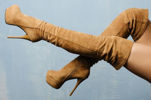 female legs in beige suede high-heeled boots.