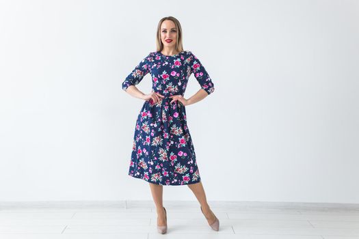 Fashionable young woman in beautiful dress posing at studio. Isolated over white.