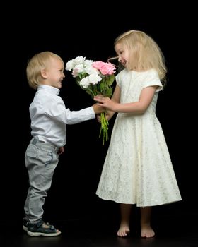 A little boy gives a girl a bouquet of flowers for his birthday. The concept of love, family values. Isolated