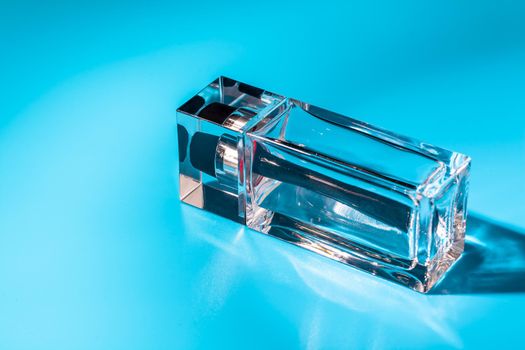 perfume glass bottle on light blue background. Eau de toilette